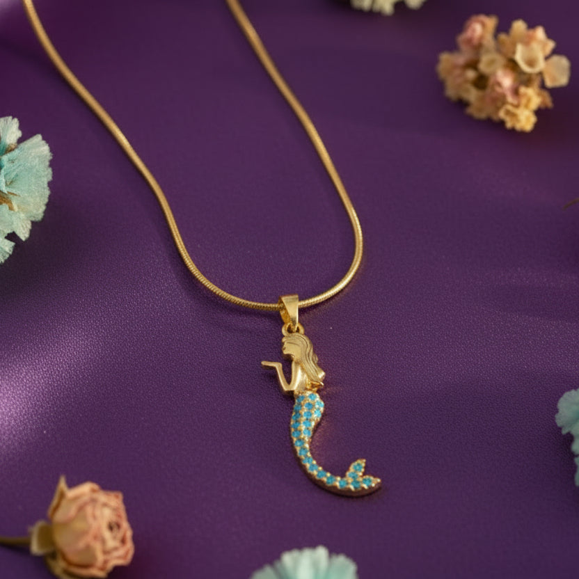 Gold necklace with a mermaid pendant on a purple background with floral decorations || Seashell4u